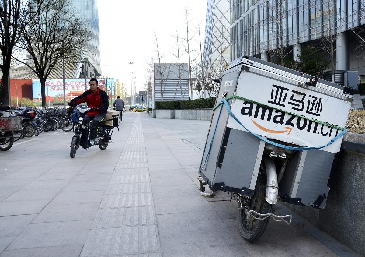 An electric bike (R) used by Amazon sits parked along the pavement at a central business district in Beijing on Nov. 29, 2012. (Wang Zhao/AFP/Getty Images)