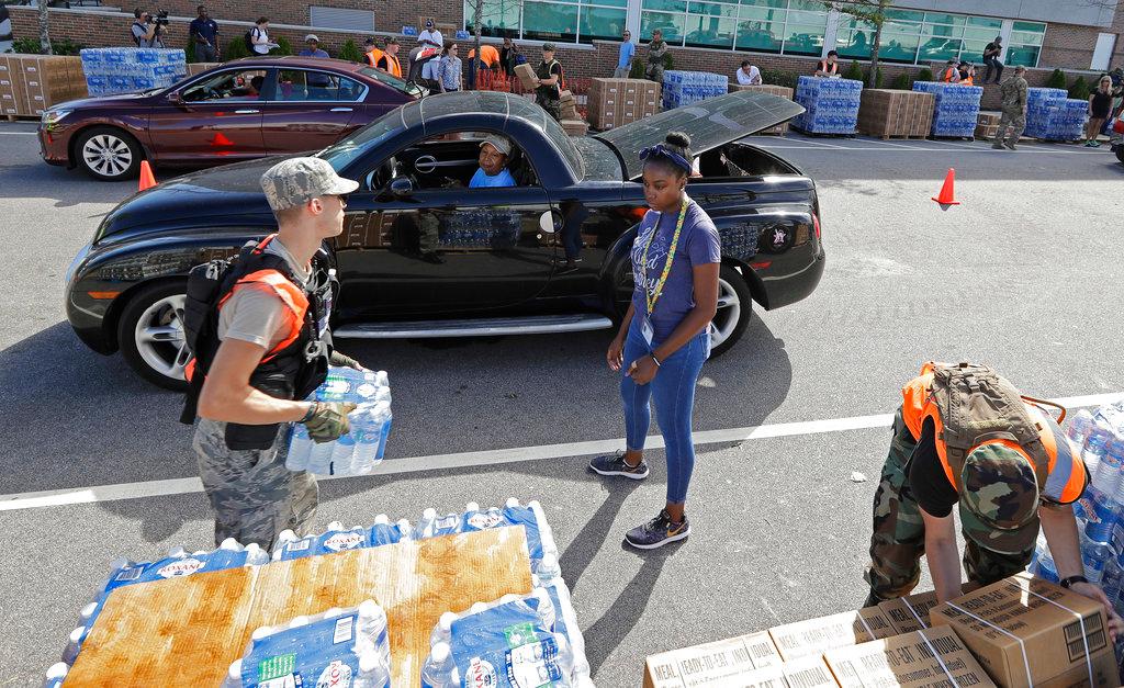 Members of the Civil Air Patrol load cars with MREs, (Meals Ready To Eat) water, and tarps at distribution area in Wilmington, N.C., Tuesday, Sept. 18, 2018. (Chuck Burton/AP Photo)