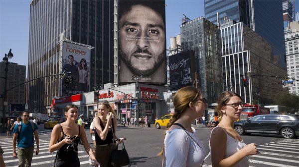 People walk by a Nike advertisement featuring Nike ambassador Colin Kaepernick, a former NFL football star, in New York City on Sept. 6, 2018. (Mark Lennihan/AP Photo)