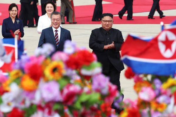 South Korean President Moon Jae-in is greeted by North Korean leader Kim Jong Un during an official welcome ceremony at Pyongyang Sunan International Airport, in Pyongyang, North Korea, on Sept. 18, 2018. (Pyeongyang Press Corps/Pool via Reuters)