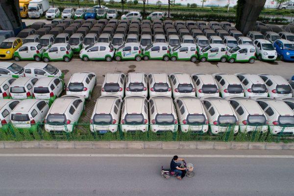 A motorist rides past new electric vehicles in Wuhan, a city in central China's Hubei Province, on May 22, 2017. (STR/AFP/Getty Images)