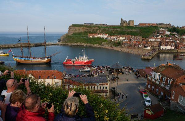 One of two full-sized replicas of HMS Endeavour is towed into Whitby Harbor in the north of England—where Captain Cook began his voyage to Australia—on June 1, 2018. (Ian Forsyth/Getty Images)