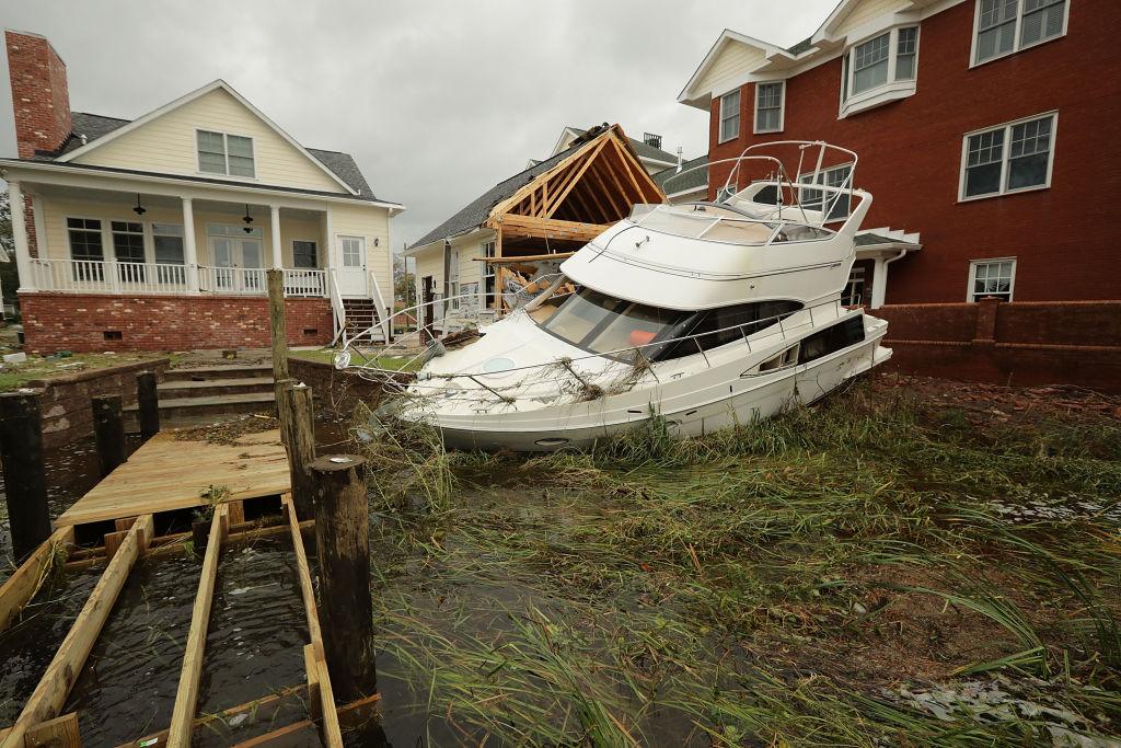A boat lies smashed against a car garage, deposited there by the high winds and storm surge from Hurricane Florence along the Neuse River in New Bern, N.C., on Sept. 15, 2018. (Chip Somodevilla/Getty Images)