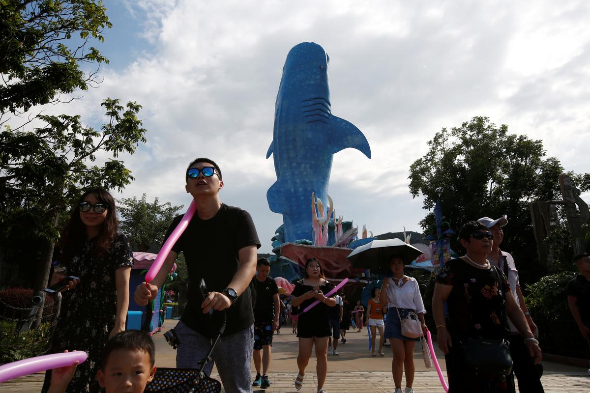 Visitors walk past a whale shark installation outside the Whale Shark Aquarium of Chimelong Ocean Kingdom in Zhuhai, China September 4, 2018. (By Bobby Yip/Reuters)