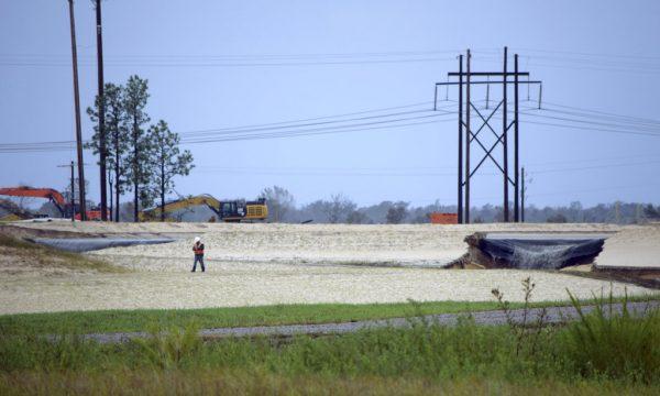 Gray water containing coal ash flows from a ruptured landfill at the L.V. Sutton Power Station in Wilmington, N.C., and flows toward Sutton Lake, near the Cape Fear River on Sept. 16, 2018. Duke Energy says its initial estimate is that about 2,000 cubic yards of ash were displaced at the landfill, enough to fill about 180 dump trucks. (Kemp Burdette/Cape Fear River Watch via AP)