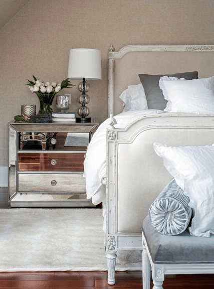 Mirrored accent furniture, such as the chic bedside table from Z Gallerie, gives the master bedroom a distinct deco feel.
