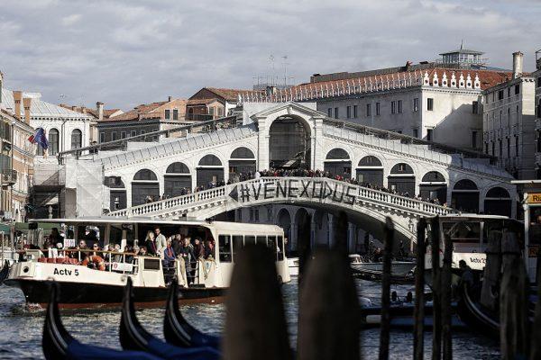 People gather on a bridge during a demonstration against the increasing number of tourists in Venice on Nov. 12, 2016. (Marco Bertorello/AFP/Getty Images)