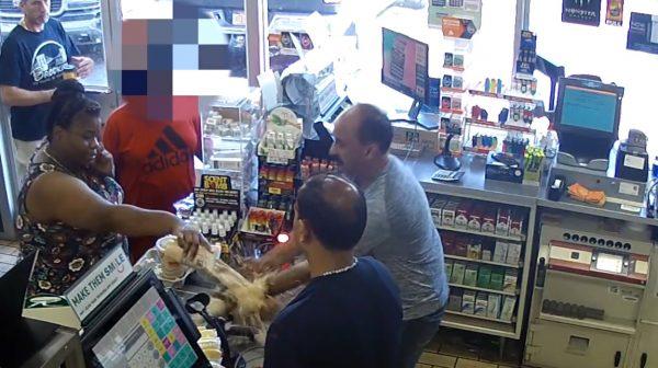 Suddenly, the woman pours out the contents of the cup all over the counter, allegedly causing damage to some merchandise. (Screengrab/ Suffolk County Police)
