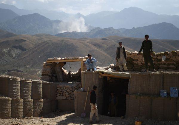 Afghan Local Police (ALP) officials look on as smoke rises after an air strike bomb on Islamic State (IS) positions in a checkpoint at the Deh Bala district in the eastern province of Nangarhar Province. (Wail Kohsar/AFP/Getty Images)