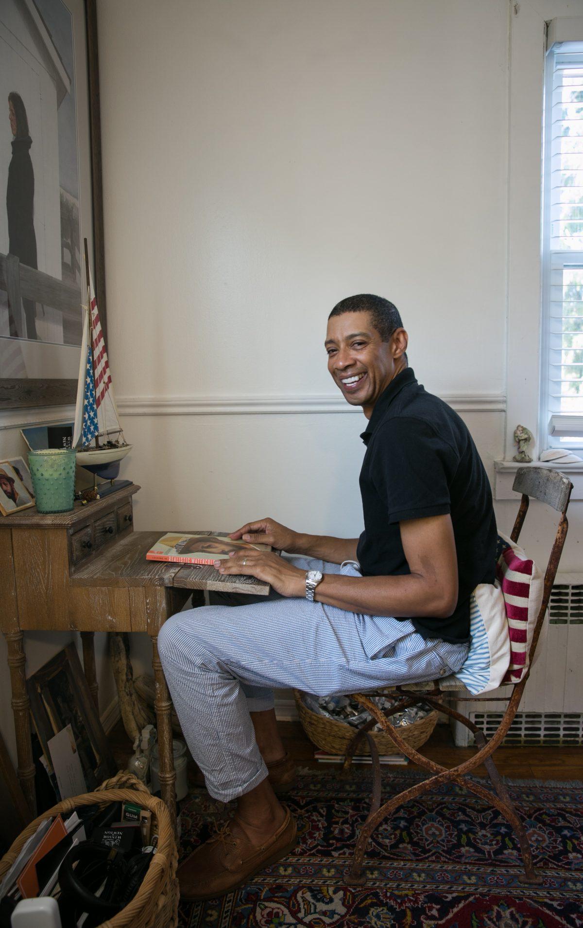 Mario A. Robinson sits at his drawing desk in his studio in Point Pleasant, New Jersey, on Sept. 4, 2018. (Milene Fernandez/The Epoch Times)