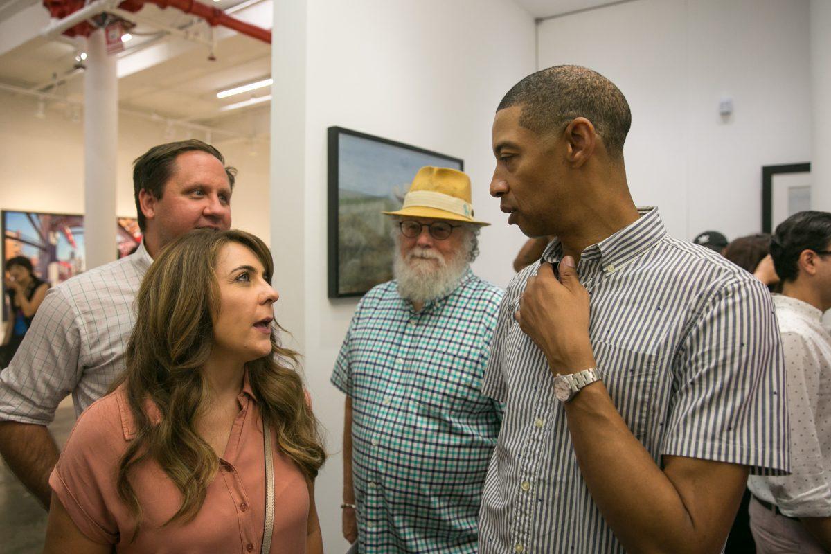 Mario A. Robinson (R) mingles with his neighbors during the opening of his show at the Bernarducci Gallery in the Chelsea district of New York, on Sept. 6, 2018. (Milene Fernandez/The Epoch Times)