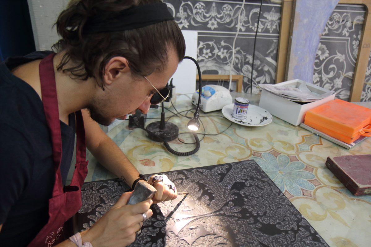 Leonardo Bianchi demonstrates engraving an intricate design into slate. (Lorraine Ferrier/The Epoch Times)