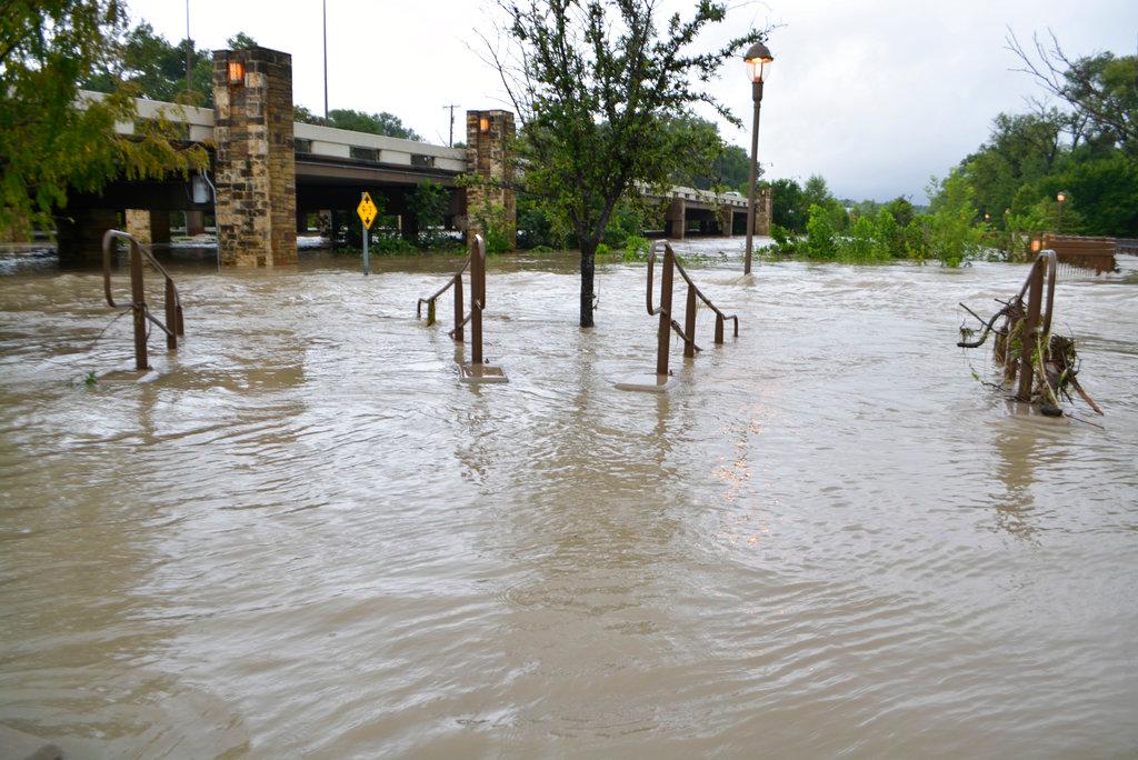 Water floods out of the banks of White Rock Creek onto the Flagpole Hill Trail in Dallas, Sept. 22, 2018. A storm system has dumped record amounts of rain in parts of Oklahoma and caused flooding in Texas, including in the Dallas area, where floodwaters swept a man from a bridge to his death. (By Brian Elledge/The Dallas Morning News/AP)
