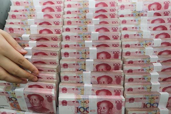 A teller counts yuan banknotes in a bank in Lianyungang, in China's Jiangsu province, on Aug. 11, 2015. (STR/AFP/Getty Images)