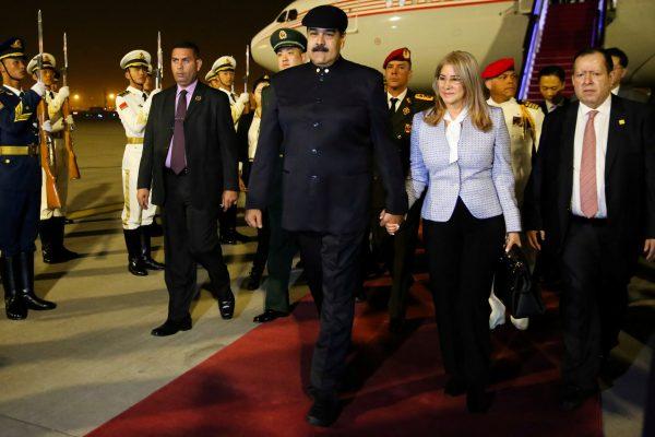 Venezuela's President Nicolas Maduro walks with his wife Cilia Flores upon their arrival at the airport in Beijing, China, on Sept. 13, 2018. (Miraflores Palace/Handout via Reuters)