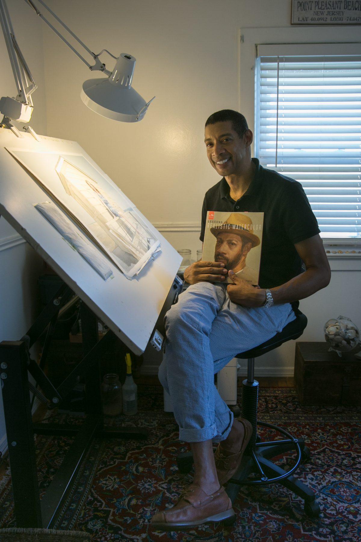Mario A. Robinson shows his paintings, drawings, and book in his studio at home in Point Pleasant, New Jersey, on Sept. 4, 2018. (Milene Fernandez/The Epoch Times)