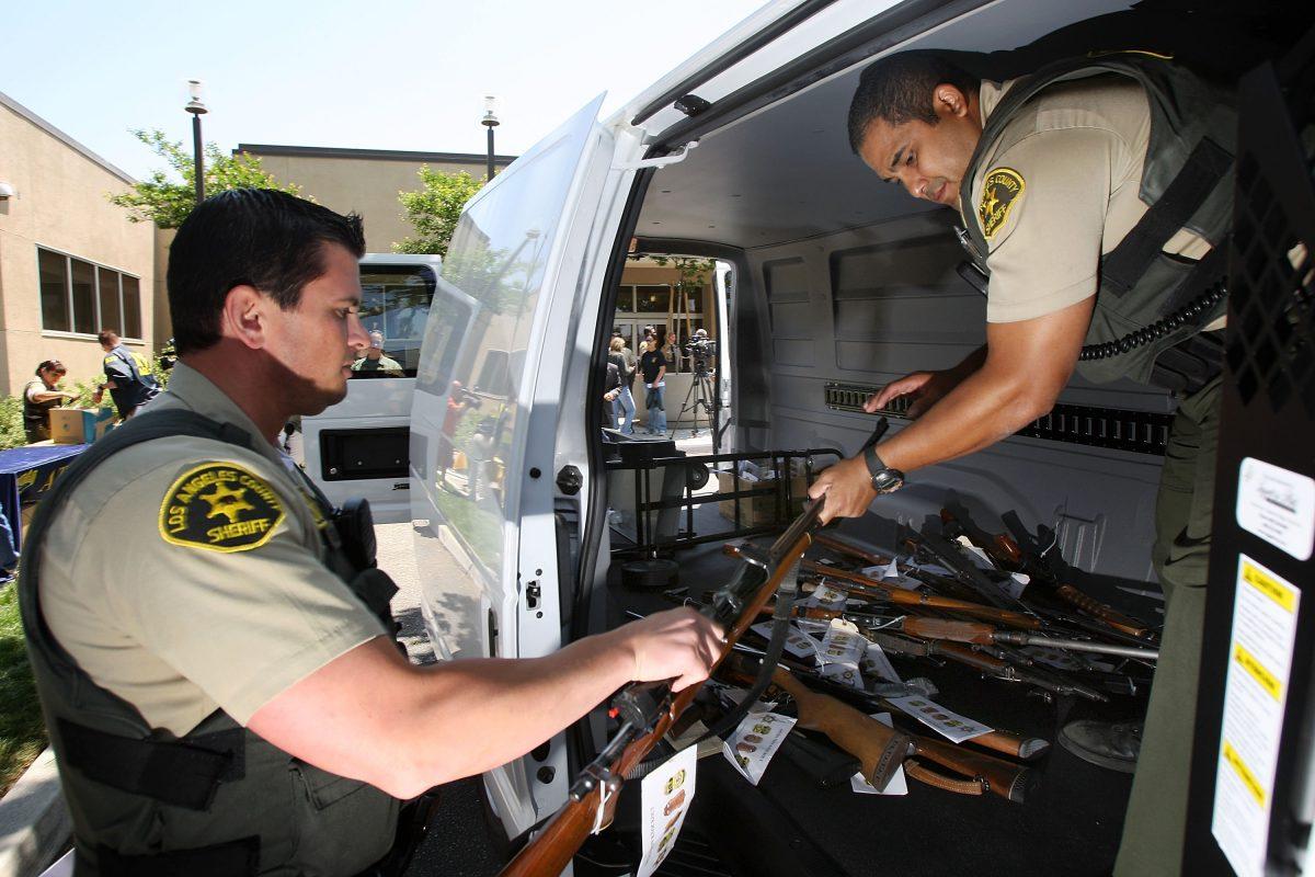 Officers load some of about 125 weapons confiscated during a gang takedown in the Los Angeles-area community of Lakewood, Calif., on May 21, 2009. Judge Steven Bailey, who is seeking to be elected California attorney general, wants to make cracking down on gangs and confiscating guns from felons to be priorities. (David McNew/Getty Images)