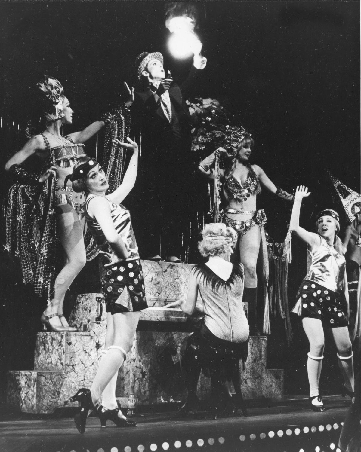 Joel Grey, in the role of Master of Ceremonies, stands on the piano during the "Money Song" at the Broadhurst Theatre in New York City in November 1966. The original Broadway musical "Cabaret" was traditionally cast. (AP)