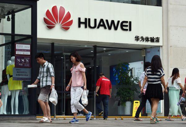 People walk past a Huawei store in Beijing on July 20, 2015. The Chinese telecoms equipment giant dominates the 5G wireless technology market, as part of Beijing's goals to achieve tech self-reliance. (Greg Baker/AFP/Getty Images)