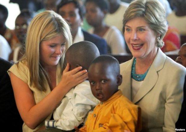 United States first lady Laura Bush and daughter Jenna, (L), hold Rwandan children they met at an AIDS project during a church service at Kagarama Church in Kigali, July 14, 2005. Bush was on the last leg of her official visit to Africa after the meeting of G8 leaders in Gleneagles, Scotland.