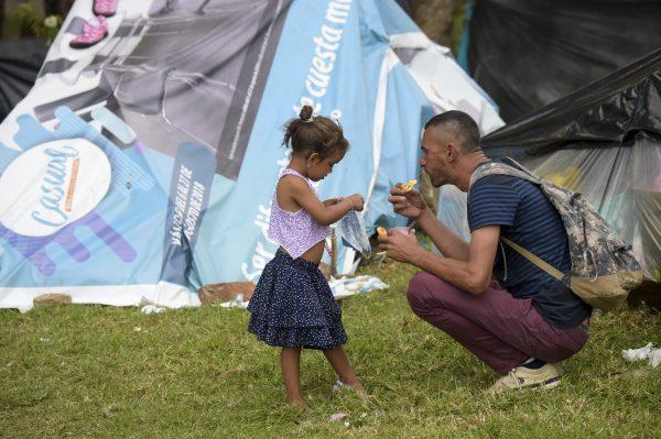 A Venezuelan migrant man and a girl at an improvised camp near the bus terminal in Bogota.