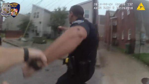 Foster pulls Lippe toward the back of the police cruiser to take cover, according to footage released on Oct. 1, 2018, by Baltimore police. (Baltimore Police Department)