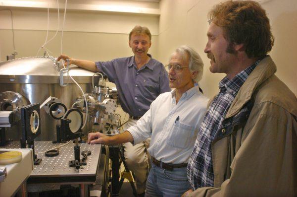 University of Michigan Professor Gerard Mourou, center, and fellow research scientists Anatoly Makisimchuk, left, and Victor Yanovsky talk about the potential of the laser dubbed Hercules that has been built over the past five years at the University of Michigan lab on June 28, 2004. (The Ann Arbor News, Robert Chase/AP)