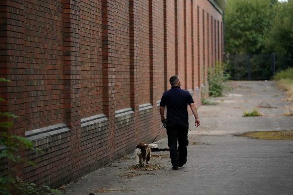 A drug search dog and officer patrol the perimeter of Birmingham Prison on Aug. 20, 2018. (Christopher Furlong/Getty Images)
