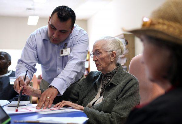 An aged care worker assists an elderly client during an activity session in a Day Care center in California on Feb. 10, 2011. (Justin Sullivan/Getty Images)