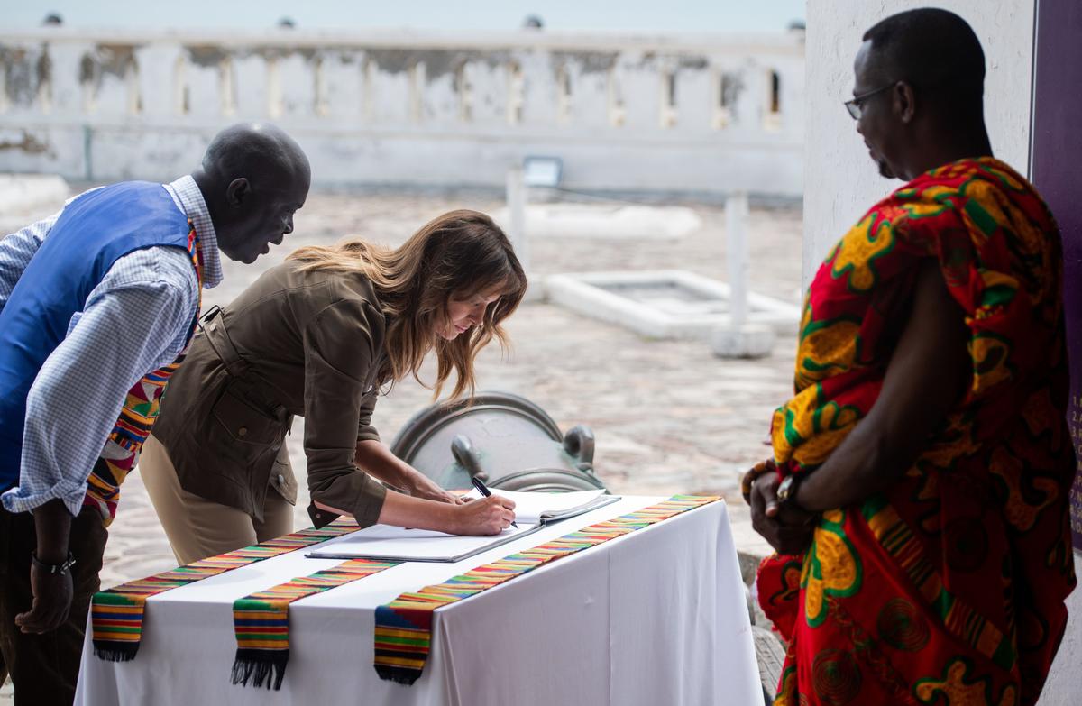 US first lady Melania Trump signs the guest book following a tour of Cape Coast Castle, a former slave trading fort, in Cape Coast, Ghana, on Oct. 3. (SAUL LOEB/AFP/Getty Images)