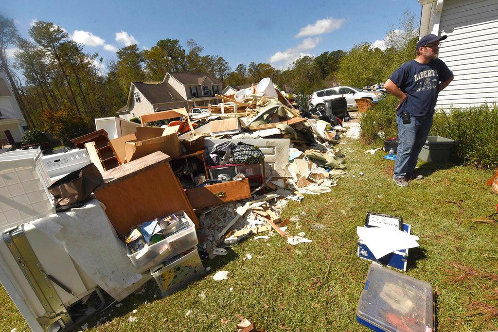 Brian Morris looks at the debris from his home in the Stoney Creek Plantation neighborhood Wednesday, Sept. 26, 2018, in Leland, N.C. Many of the homes here were flooded through their bottom floors due to rains from Hurricane Florence. (Ken Blevins /The Star-News/AP)