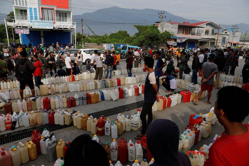 People wait to buy gasoline at Pertamina gas station in Palu, Indonesia, Oct. 4, 2018. (Reuters/Beawiharta)