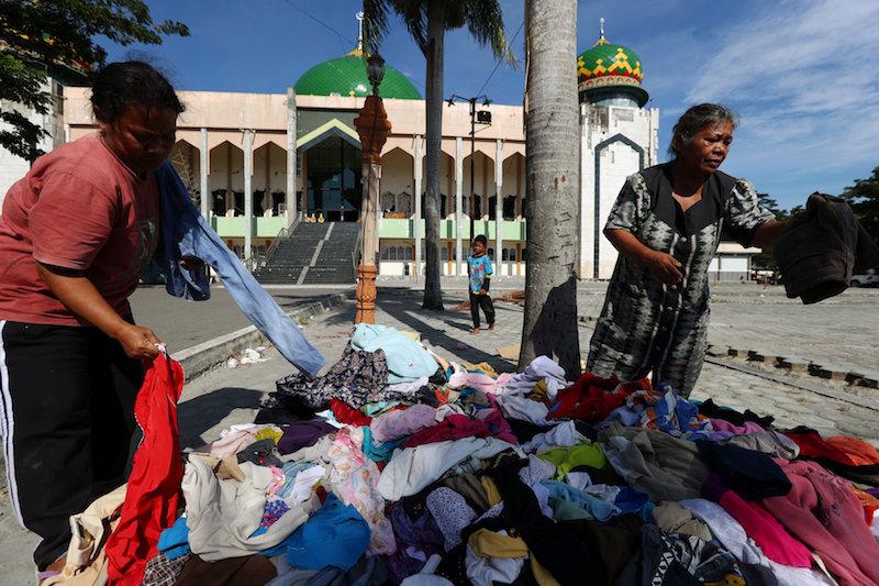 Local residents affected by the earthquake and tsunami search through donated clothes at a mosque in Palu, Central Sulawesi, Indonesia, Oct. 5, 2018. (Reuters/Athit Perawongmetha)