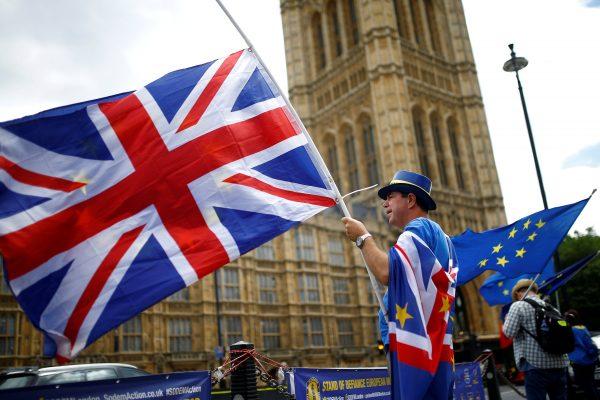 Anti-Brexit demonstrators wave EU and Union flags opposite the Houses of Parliament in London on June 19, 2018. (Henry Nicholls/Reuters)