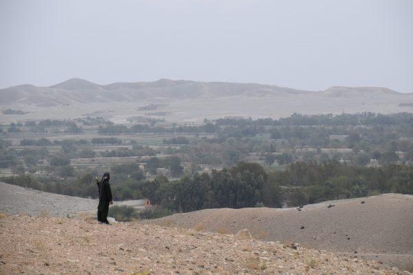 A member of an armed pro-government uprising group overlooks Taliban-held areas just outside of Kaga, the center of the district of Khogyani in the eastern Afghan province of Nangarhar, on Oct. 2, 2018. (Franz J. Marty/Special to The Epoch Times)