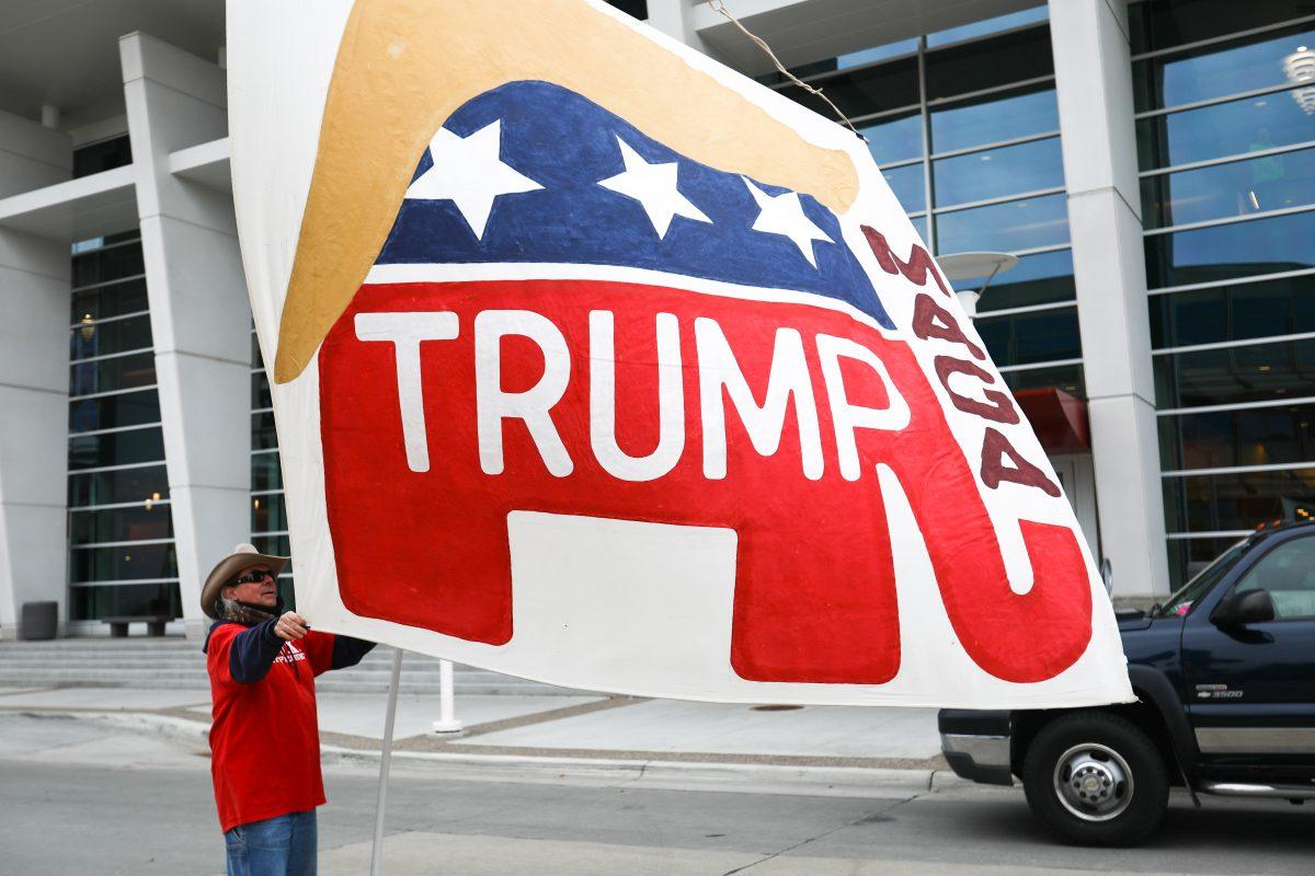 Will from Wisconsin waves a giant, handmade flag outside the Mayo Civic Center before a Make America Great Again rally in Rochester, Minn., on Oct. 4, 2018. (Charlotte Cuthbertson/The Epoch Times)
