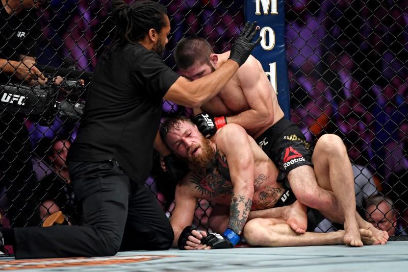 Conor McGregor (blue gloves) taps out against Khabib Nurmagomedov (red gloves) during UFC 229 at T-Mobile Arena. A brawl broke out moments later, resulting in the arrest of 3 of Numagomedov’s team-mates. (Stephen R. Sylvanie-USA TODAY Sports)