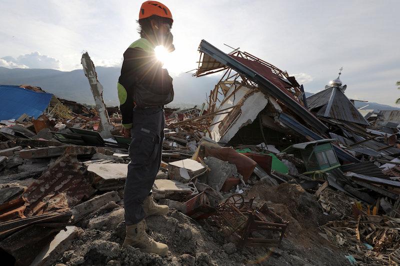 A rescue worker works after an earthquake in the Balaroa neighbourhood in Palu, Central Sulawesi, Indonesia, Oct. 7, 2018. (Reuters/Jorge Silva)