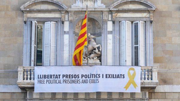 A banner under the Catalan flag on Palau de la Generalitat, the seat of the government of Catalonia, reads “Free political prisoners and exiles,” on Oct. 3, 2018, in Barcelona, Spain. (Anna Llado/Special to The Epoch Times)