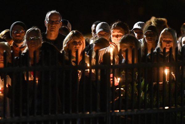 Family members and friends gather for a candlelight vigil memorial at Mohawk Valley Gateway Overlook Pedestrian Bridge in Amsterdam, N.Y., on Oct. 8, 2018. The memorial honored 20 people who died in Saturday's fatal limousine crash in Schoharie, N.Y. (AP Photo/Hans Pennink)