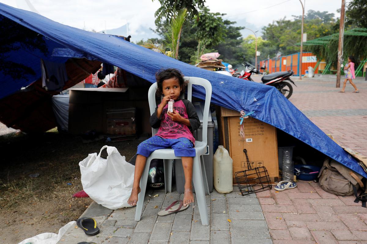 A boy sits outside his tent in a camp for displaced victims of the earthquake and tsunami in Palu, Central Sulawesi, Indonesia, Oct. 9, 2018. (Darren Whiteside/Reuters)
