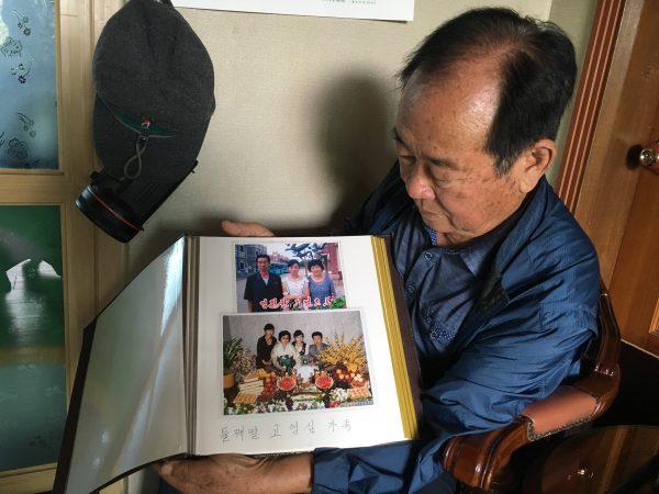Koh Ho-jun shows photos of the family of one of his nieces in North Korea that he received during an inter-Korean family reunion, in his home in Cheongju, South Korea, on Oct. 2, 2018. (Seungmock Oh/Special to The Epoch Times)