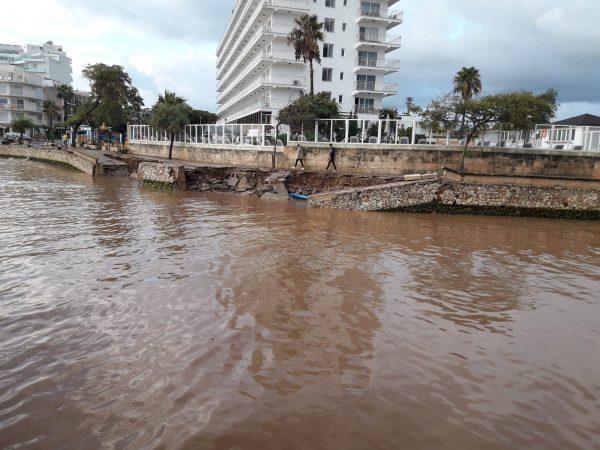 People walk along the damaged waterfront after a storm on the island of Mallorca, Spain, on Oct. 10, 2018. (Joan Camacho/Reuters)