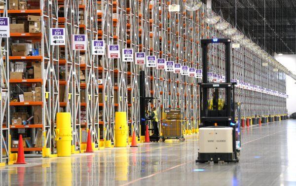 A worker drives a powered industrial truck at the Amazon fulfillment center in Aurora, Colo., on May 3, 2018. (Rick T. Wilking/Getty Images)