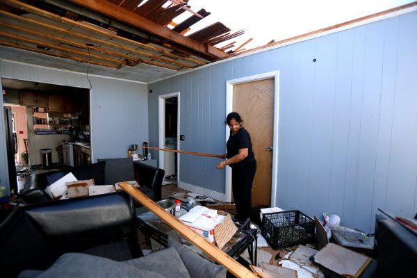 Jyotsana Patel picks up debris in her home damaged by Hurricane Michael in Parker, Fla., on Oct. 11, 2018. (Jonathan Bachman/Reuters)