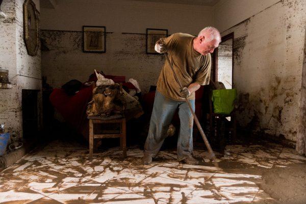 A man cleans his house after flooding in Sant Llorenc, Oct. 10, 2018. (Francisco Ubilla/AP Photo)