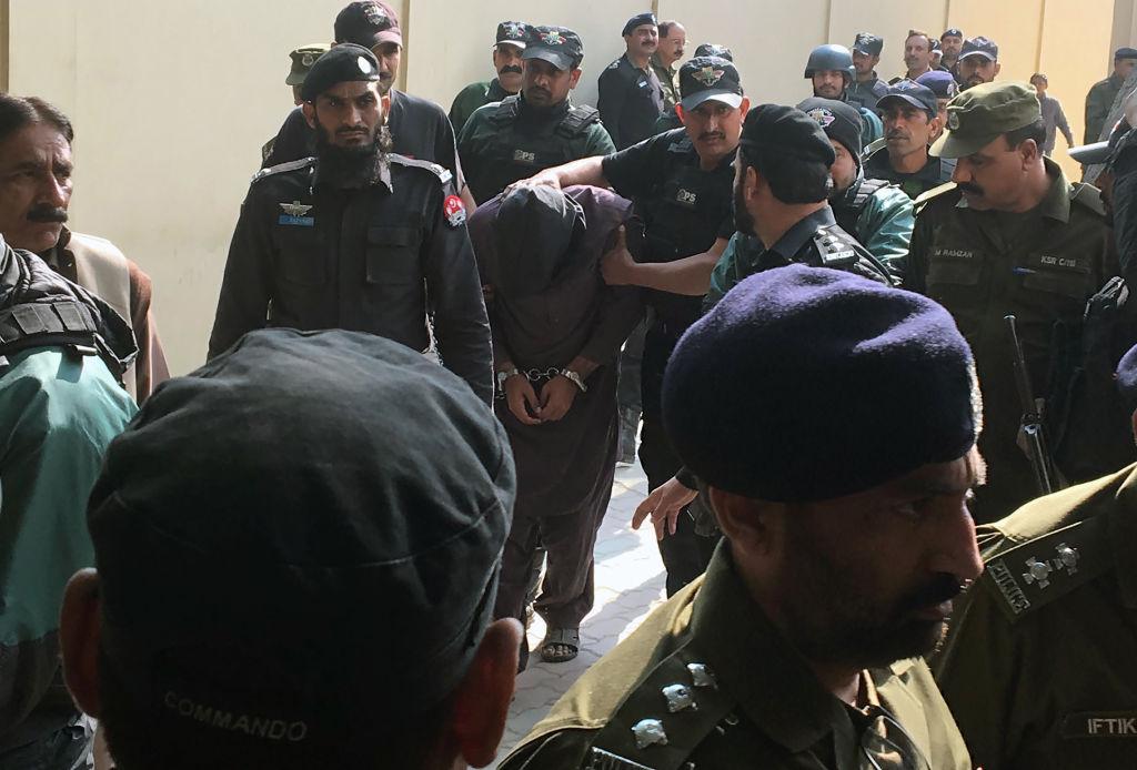 Pakistani policemen escort Imran Ali, convicted or raping and murdering multiple young girls, as they leave an anti-terrorist court after a hearing in Lahore on Feb. 9, 2018. Imran was sentenced to death on Oct. 12, 2018. (AFP/Getty Images)
