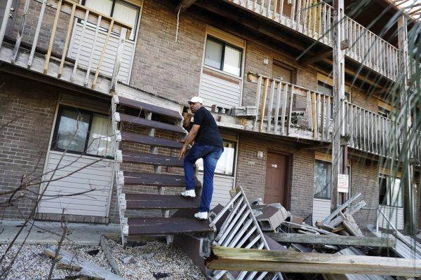 David Blackston climbs a damaged stairway to check on his second-floor apartment in the aftermath of hurricane Michael in Callaway, Fla., on Oct. 11, 2018. (AP Photo/David Goldman)