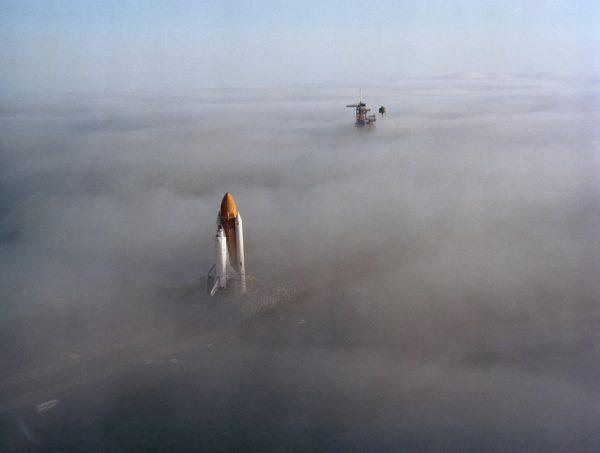 The Space Shuttle Challenger, atop a mobile launch platform, slowly moves through the Florida fog to Launch Pad 39A in preparation for its first liftoff on the STS-6 mission. The fully assembled Shuttle, weighting 12,000 pounds less than predecessor Columbia, completed the trip to the pad in just over six hours on Nov. 30, 1982. (NASA)