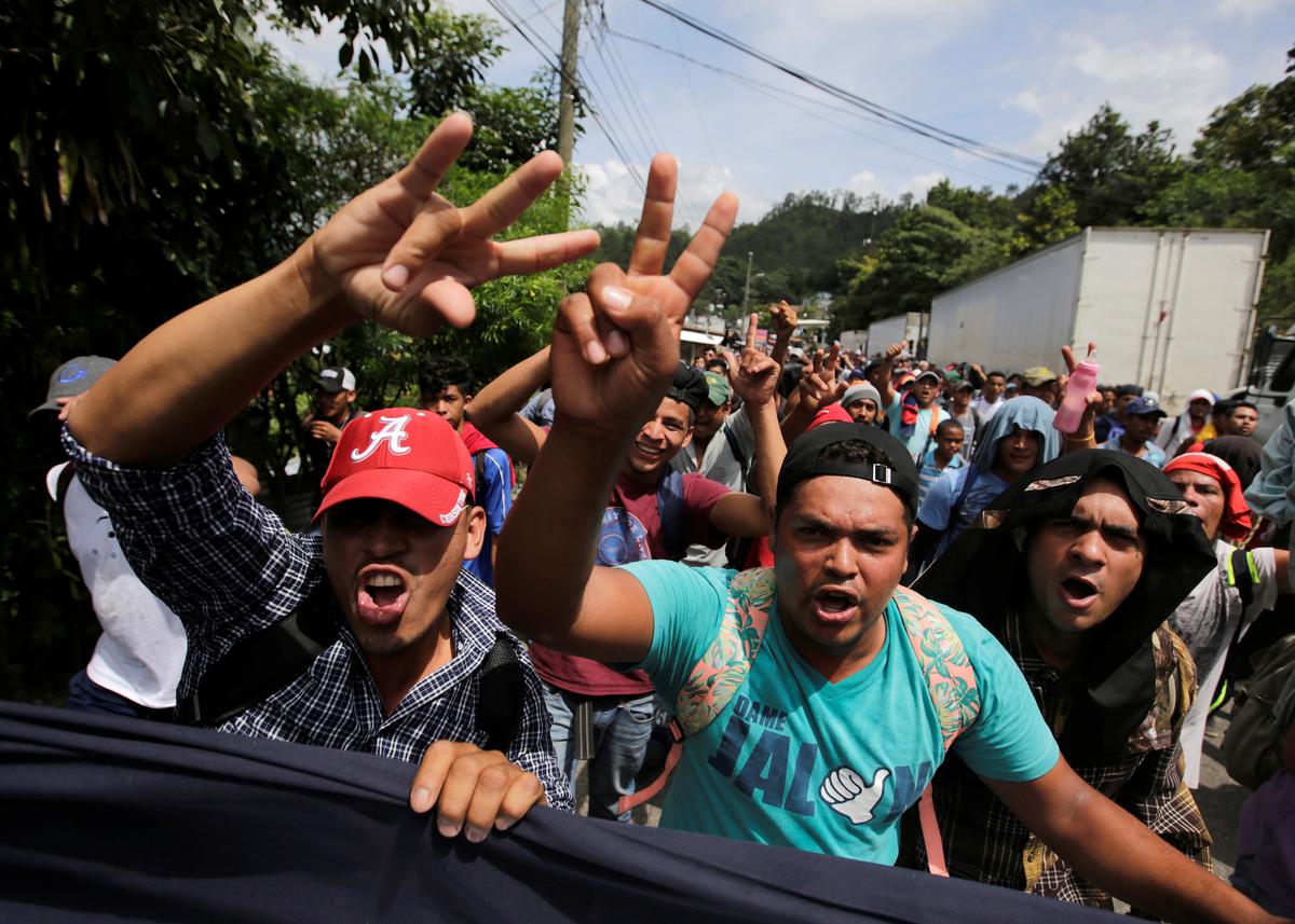 Honduran migrants, part of a caravan trying to reach the United States, gesture while arriving at the border between Honduras and Guatemala, in Agua Caliente, Guatemala, on Oct. 15, 2018. (Jorge Cabrera/Reuters)